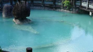 The hot spring view with the steam rising up from the hot water surface photo