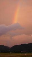 el colorido arco iris se eleva en el cielo después de la lluvia de verano foto