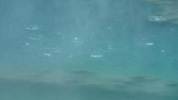 The hot spring view with the steam rising up from the hot water surface photo