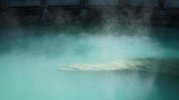 The hot spring view with the steam rising up from the hot water surface photo