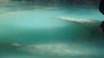 The hot spring view with the steam rising up from the hot water surface photo