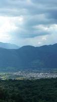 The harvesting yellow rice field view located in the valley among the mountains with the cloudy sky as background photo