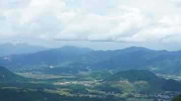 la cosecha de la vista del campo de arroz amarillo ubicada en el valle entre las montañas con el cielo nublado como fondo foto