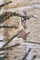 estrella de madera en la rama del árbol de navidad. adornos navideños hechos a mano sin desperdicios foto