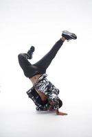 Cool young break dancer performing in studio on white background. photo