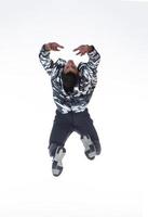 Cool young break dancer performing in studio on white background. photo