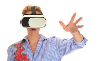 Pretty beautiful excited woman in VR headset looking up and trying to touch objects in virtual reality photo