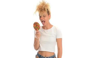 Blonde woman licking sweet candy. Female model eating delicious confectionery lollipop with surprised expression. studio shot isolated white background, photo