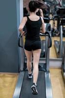 Young woman workout on treadmill in gym. Healthy lifestyle. photo