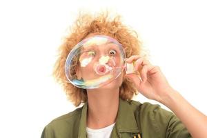Attractive young female model blowing soap bubbles photo