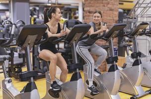 Two young woman workout in gym. Healthy lifestyle. Selective focus. Motion Blur. photo