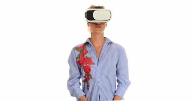Pretty beautiful excited woman in VR headset looking up and trying to touch objects in virtual reality photo