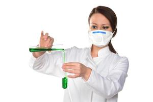 Female scientist holding two tubes transferring green liquid from one to another. Isolated on white background. photo