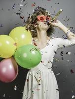 Beautiful woman celebrating New Year with confetti and holding sign. photo