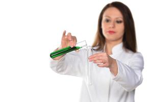 Female scientist holding two tubes transferring green liquid from one to another. Isolated on white background. photo