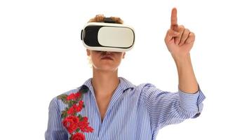 Pretty beautiful excited woman in VR headset looking up and trying to touch objects in virtual reality photo