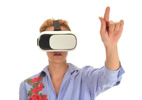 Pretty beautiful excited woman in VR headset looking up and trying to touch objects in virtual reality photo