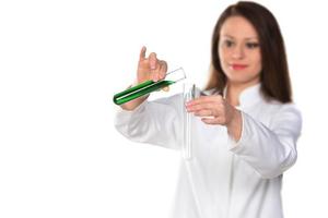 Female scientist holding two tubes transferring green liquid from one to another. Isolated on white background. photo