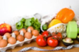 Defocused image for text with Vegetables anf fruit near dumbbells and measuring tape. Sport and diet cocnept. HEalthy eating habits photo