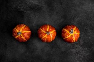 Modern Halloween background with pumpkins against black concrete background. photo