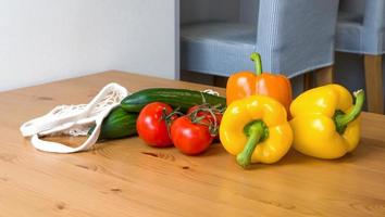 Fresh ripe vegetables in string bag with heart near. Zero waste. Harvest.Healthy eating.Diet. Sustainable shopping photo