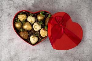 Top view on Heart shaped box with assorted chocolate covered strawberries on a gray background.St Valentine's,mother's day concept photo