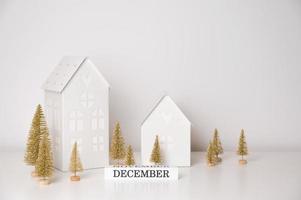 Golden christmas background with topy houses,fir trees and december sign photo