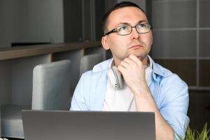 Puzzled asian man using laptop for work,education,programming etc. photo