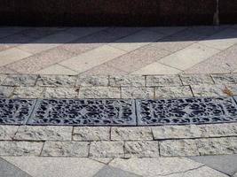 Storm drain in stone tiles. Urban environment. photo