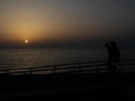 Seashore at sunset. Dark photograph of the sunset sky. Warmer climes photo