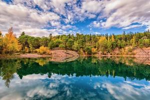 vista escénica del espejo como reflejo del lago carces en el sur de francia en colores otoñales contra el cielo dramático foto