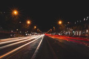 vista panorámica de los senderos del semáforo en los campos elíseos en parís por la noche foto