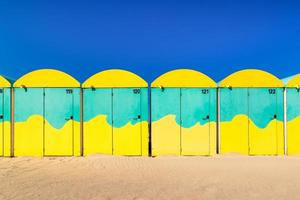 Scenic view of colored beach cabins at the beach in Dunkirk, France against blue summer sky photo