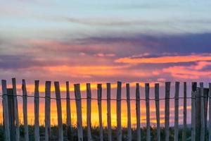 vista escénica de la valla de madera en la playa contra el espectacular cielo de la puesta de sol en saint tropez al sur de francia foto