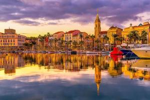 vista panorámica de las luces navideñas iluminadas puerto de sanary sur mer en el sur de francia reflejado en el mar mediterráneo durante la colorida puesta de sol foto