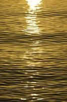 vista panorámica de las olas en la luz amarilla del atardecer foto