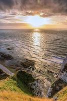 vista panorámica del mar contra la luz del atardecer en etretat en francia foto