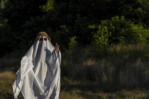 White ghost with black eyes, made from a bedsheet. whit hat photo