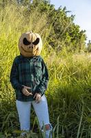 mujer joven con cabeza de calabaza después de cortarla y ponerle cara, halloween, foto