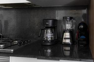 Different clean plates in dish drying rack on kitchen counter photo