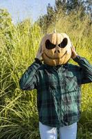 young woman with pumpkin head after cutting it off and putting a face on it, halloween, photo