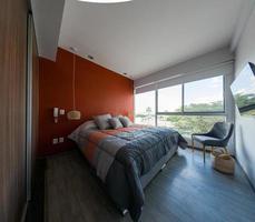 elegante interior de dormitorio contemporáneo con muebles cómodos. cama para dos con manta foto