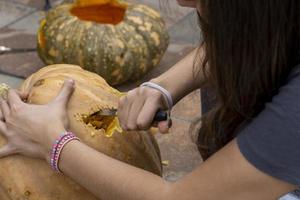 Carved Halloween pumpkin, jack lantern, with carving tools. Spooky laughing, scary head. photo