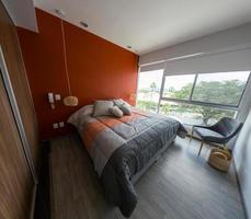 elegante interior de dormitorio contemporáneo con muebles cómodos. cama para dos con manta foto