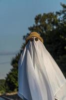 White ghost with black eyes, made from a bedsheet. whit hat photo