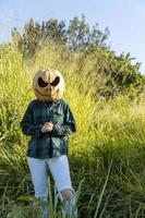 young woman with a pumpkin on her head for halloween, day of the dead, mexico photo