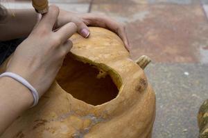 calabaza de halloween tallada, linterna jack, con herramientas para tallar. risa espeluznante, cabeza aterradora. foto