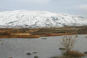 A typical icelandic landscape with mountains, rivers, snow and vegetation 11 photo