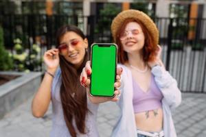 Girlfriends shows their phone to the camera photo