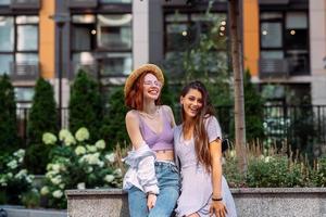 Two young women pose against the background of a building photo